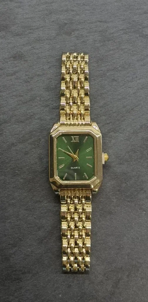 women's gold watch with a green dial